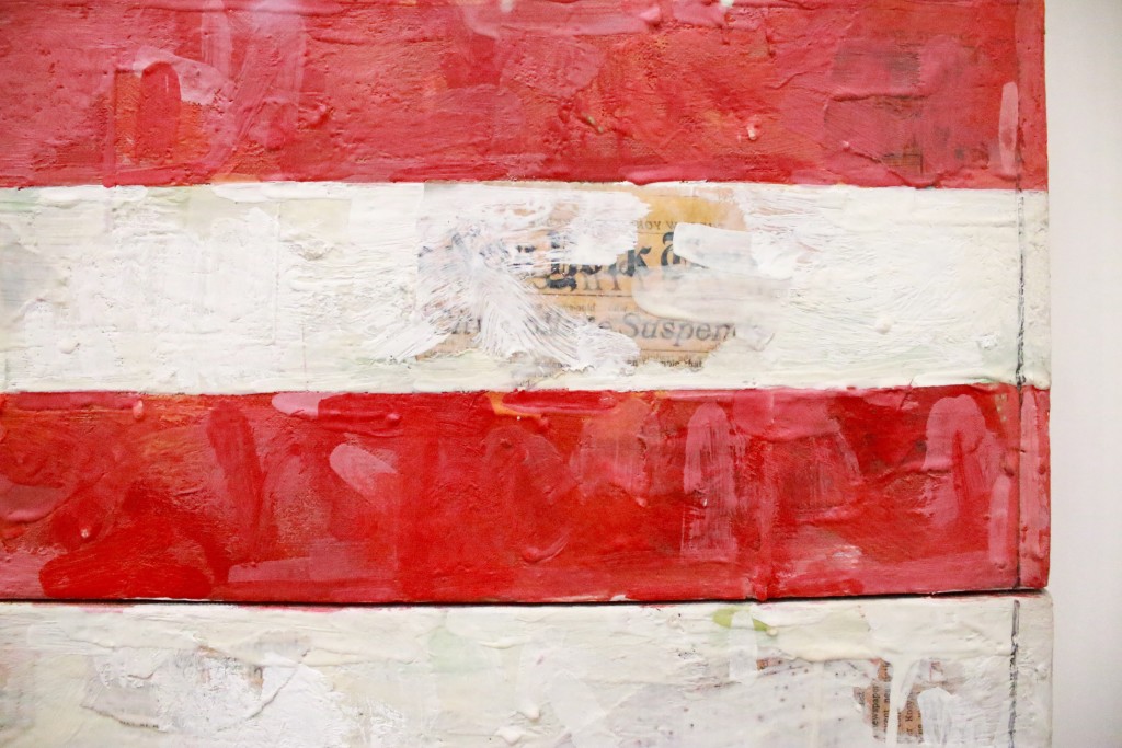 The collage work behind the Jasper Johns flag